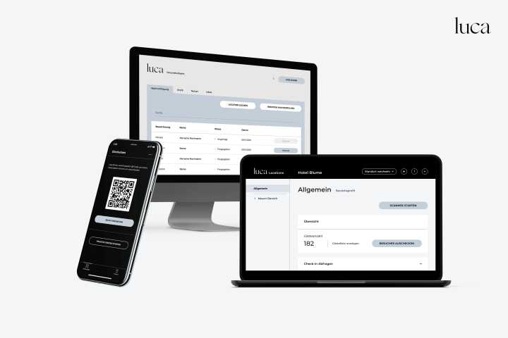 Zwei Laptops und ein Smartphone zeigen die Benutzeroberfläche der Luca-App. Auf den Bildschirmen sind Datenanzeigen und eine QR-Code-Option sichtbar. Die Geräte sind modern und professionell gestaltet, um eine digitale Lösung darzustellen.